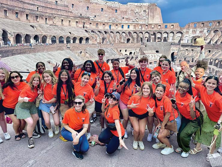 Image of a group of AHS students posing for a photo at the top of the Colosseum in Rome, Italy