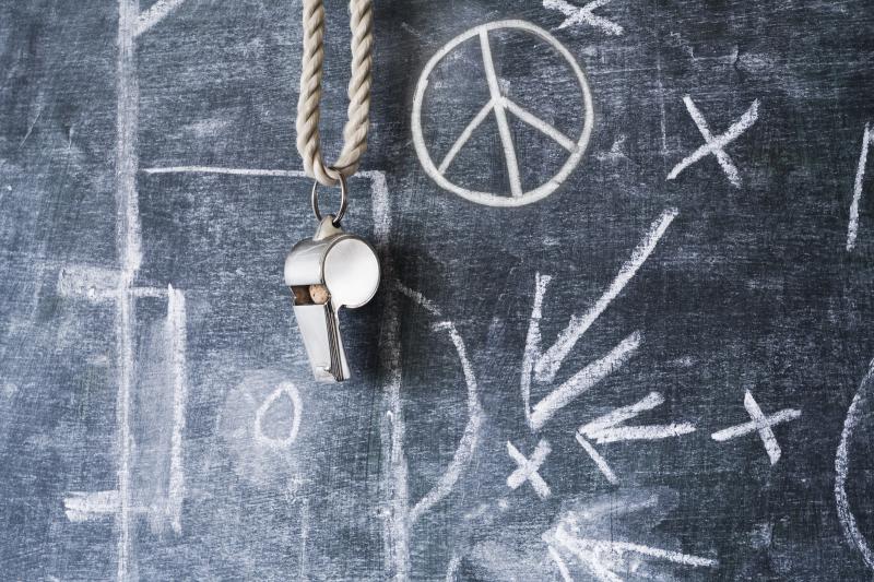 Sports whistle on a chalkboard.