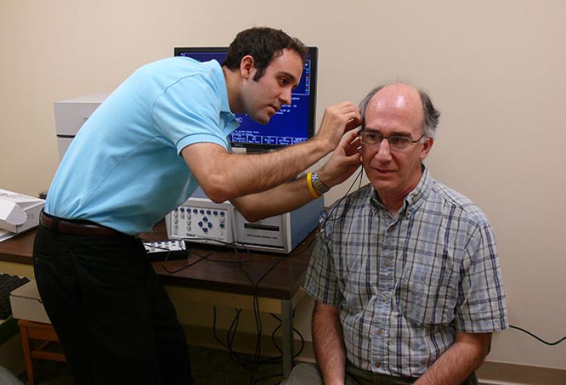 Audiology clinic student examines patient