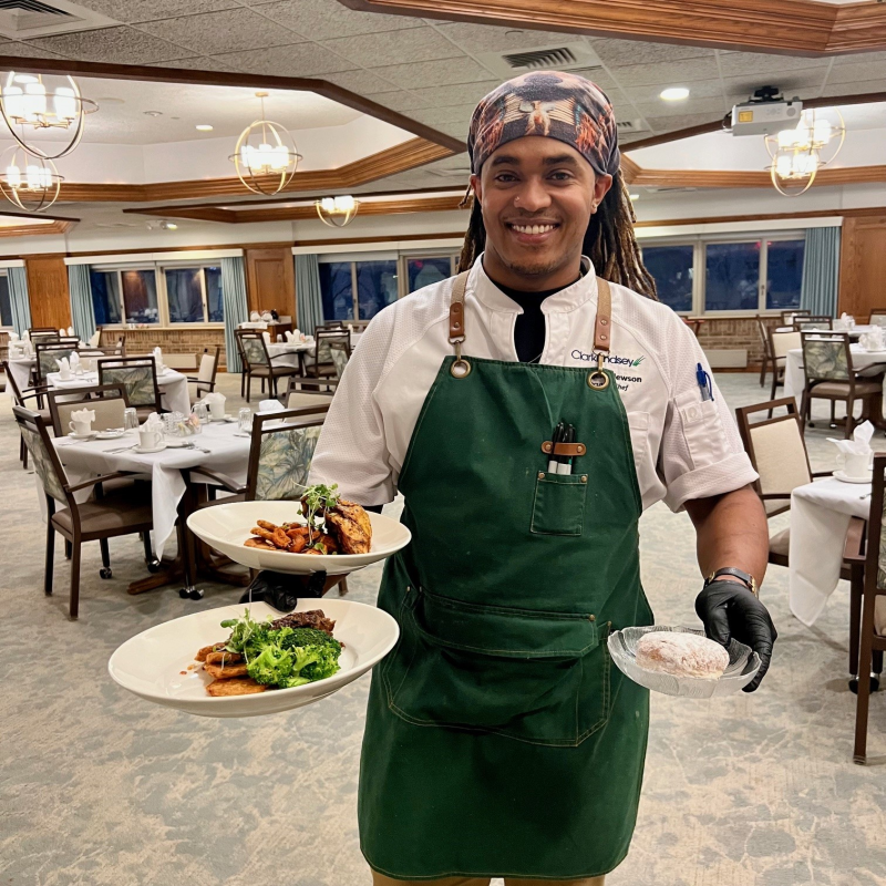 ClarkLindsey's Executive Chef, DeAngelo Newson, presents a special Hanukkah dinner for residents: beef brisket with latkes and sufganiyot. In 2025, ClarkLindsey food personnel will test out culturally diverse seasonings as part of a KCH research project. 