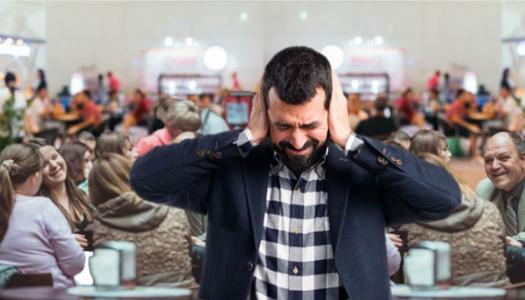 man covering his ears in noisy restaurant