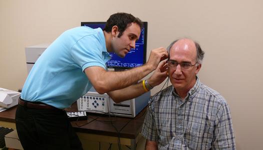 Audiology clinic student examines patient