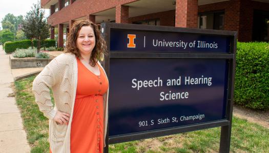 Third-year audiology doctoral student Kaley Graves stands next to the Speech and Hearing Science Building. 
